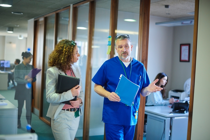 two healthcare professionals and a doctor walking through a hospital hallway discussing casechek’s rep-managed supply chain solutions