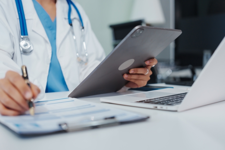 Doctor at their hospital desk reviewing bill-only process through casechek’s supply chain management solutions to improve workflows