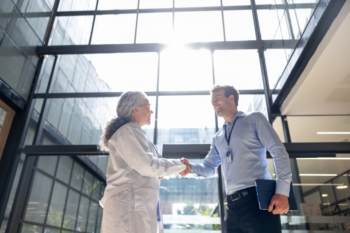 Healthcare professional and vendor representative shaking hands to represent stronger hospital supply chain partnerships and implant workflow collaboration